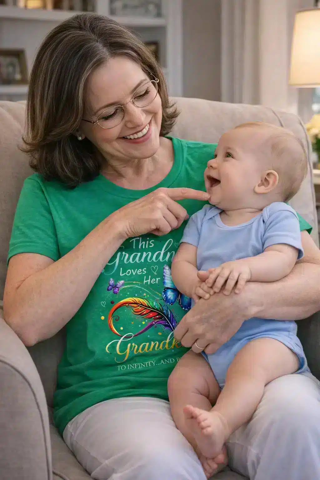 Grandma holding a baby. She is wearing a Green T-shirt with graphics of butterflies. The words "This grandma loves her Grandkids To Infinity and Beyond"